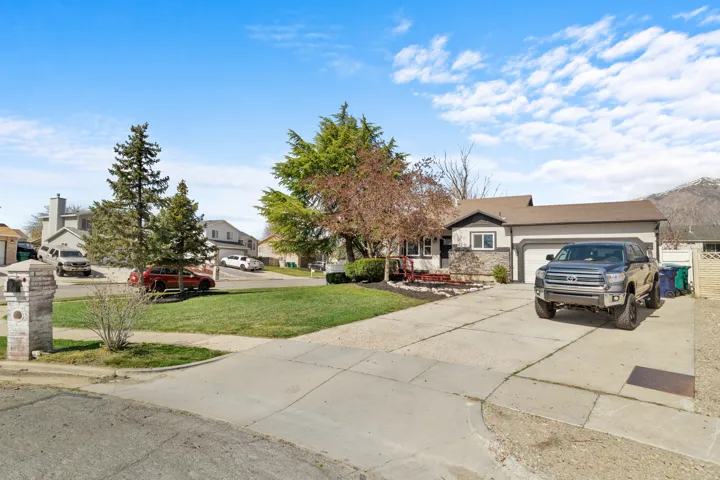 View of front of home with driveway, a front lawn, a garage, and a residential view