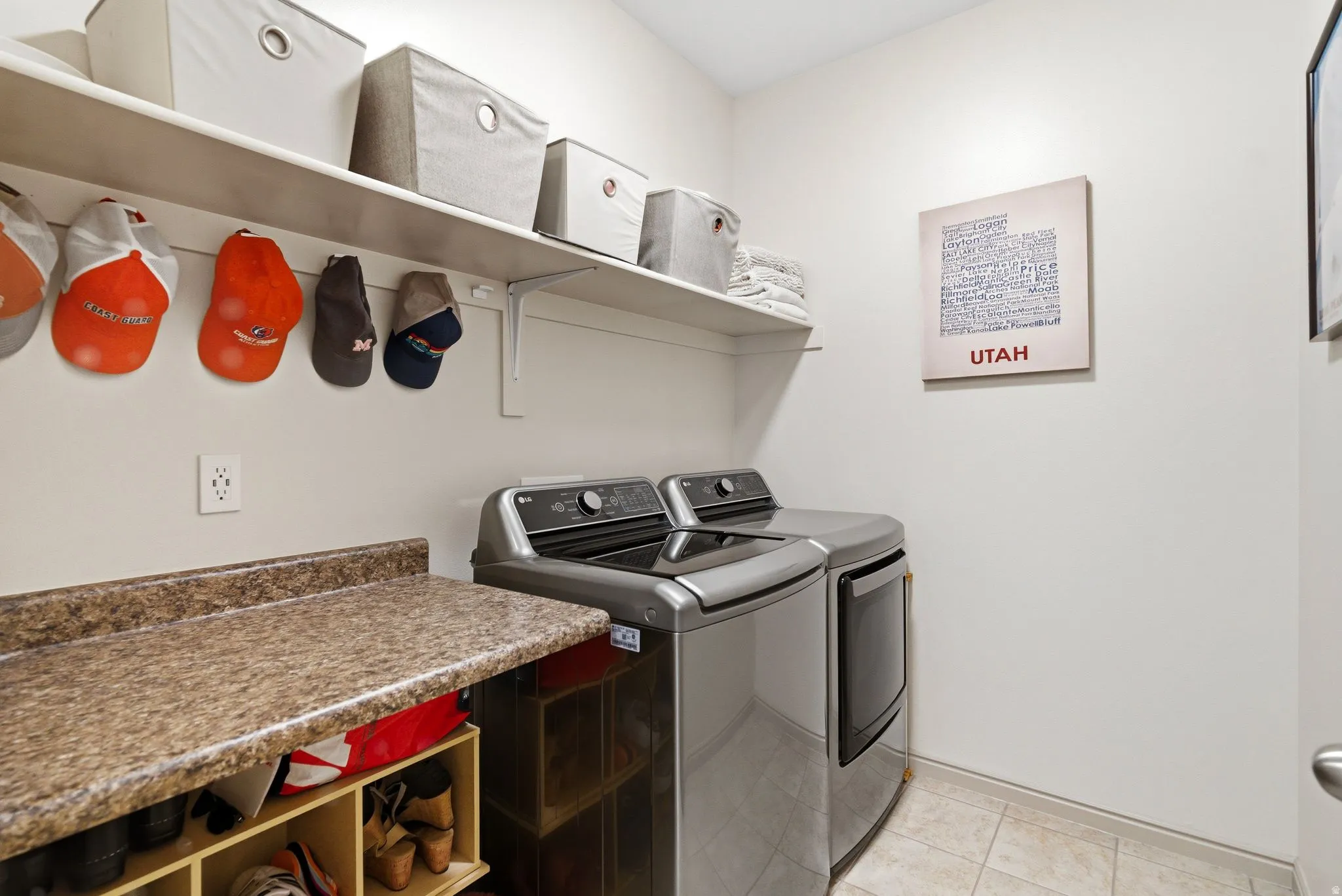 Laundry area featuring washer and clothes dryer and light tile patterned flooring