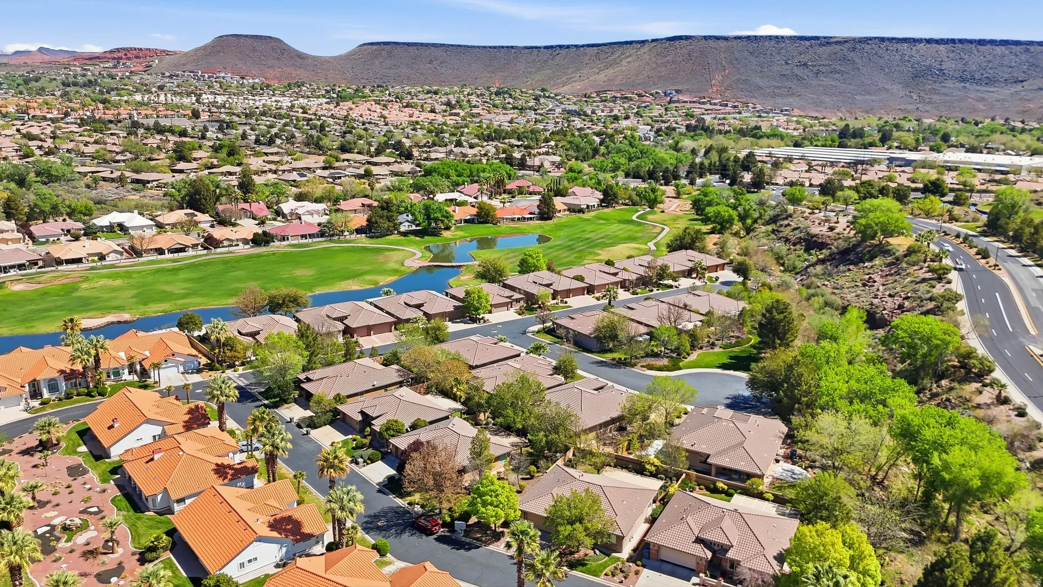 Aerial perspective of suburban area with a water and mountain view and a golf club