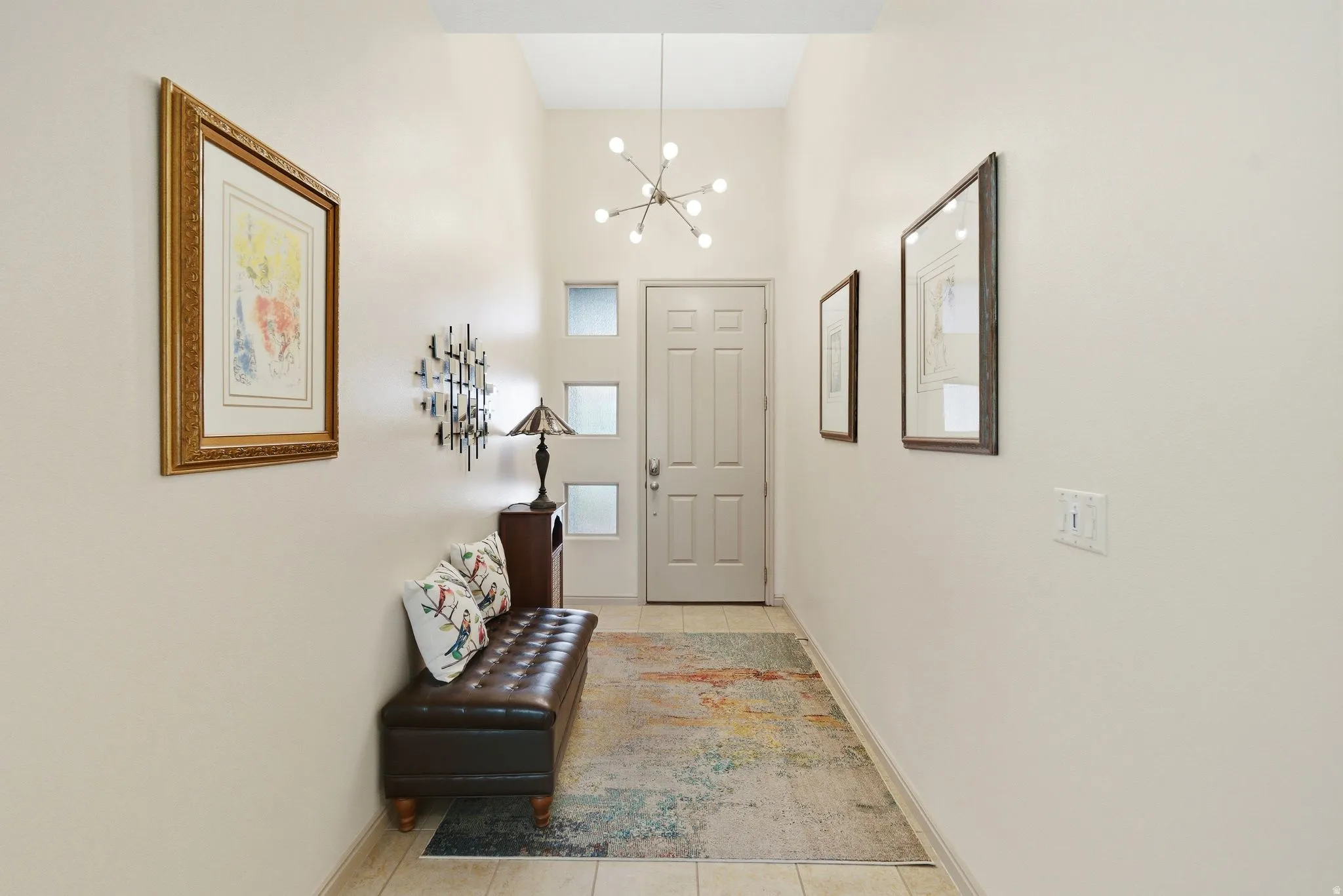Foyer with light tile patterned floors and a chandelier
