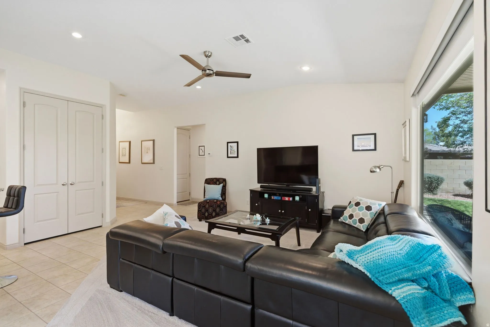 Living area featuring ceiling fan, light tile patterned flooring, recessed lighting, and vaulted ceiling