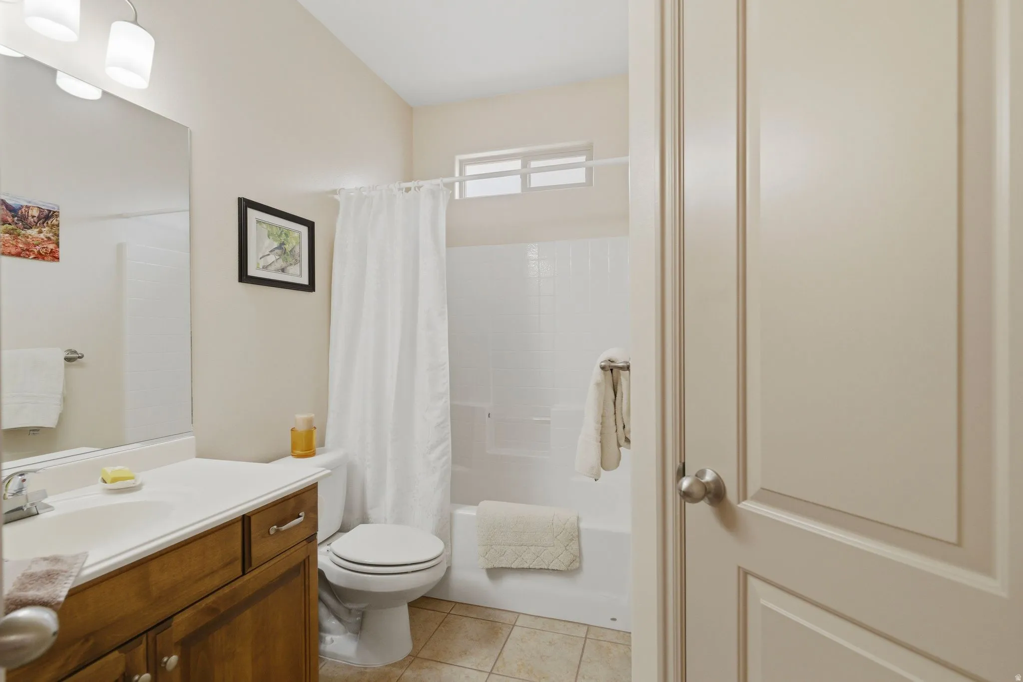 Bathroom with vanity, shower / bath combination with curtain, and light tile patterned floors