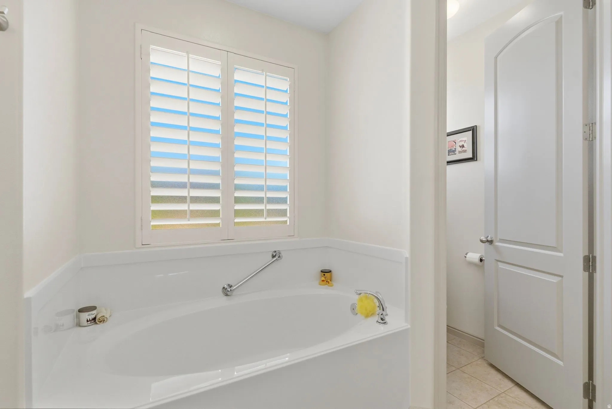 Full bathroom featuring a bath and light tile patterned floors