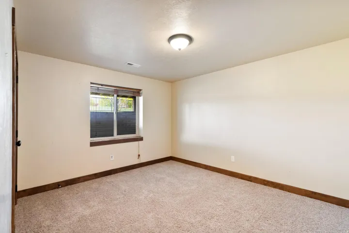 Spare room with baseboards and light carpet