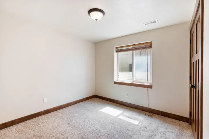Unfurnished room with baseboards and light carpet