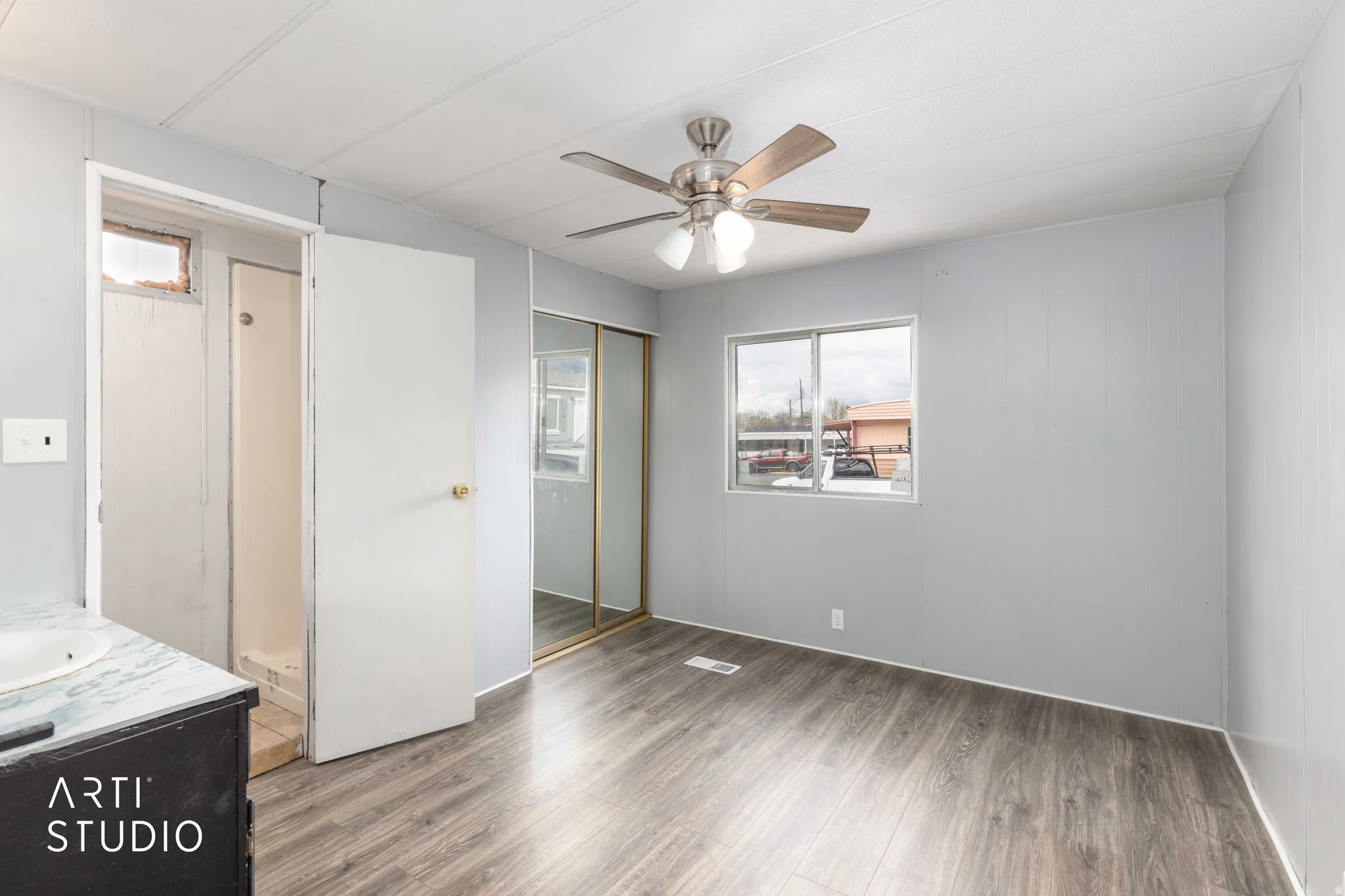 Unfurnished bedroom with wood finished floors, ceiling fan, and a closet