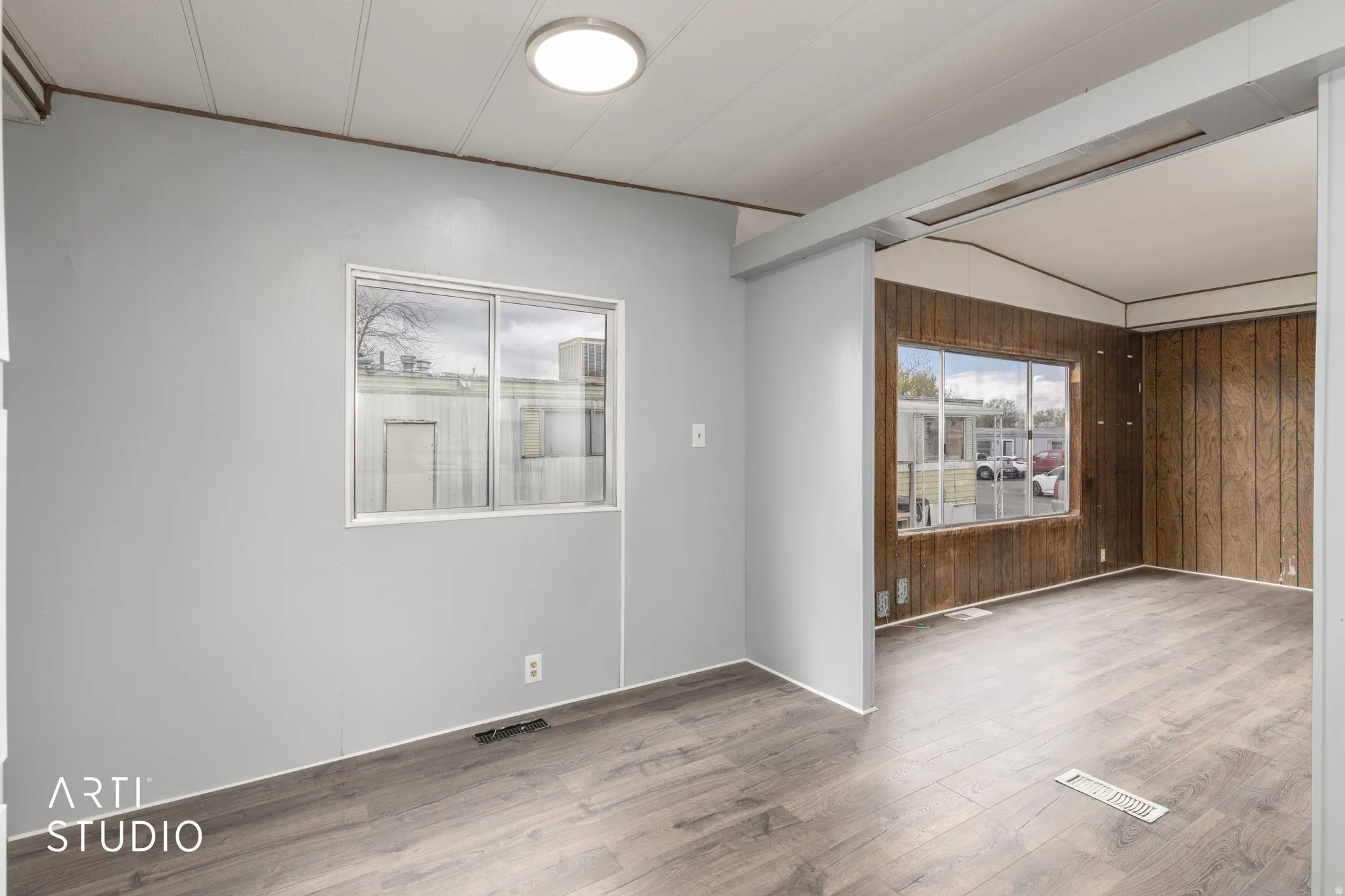 Unfurnished room featuring wooden walls and wood finished floors