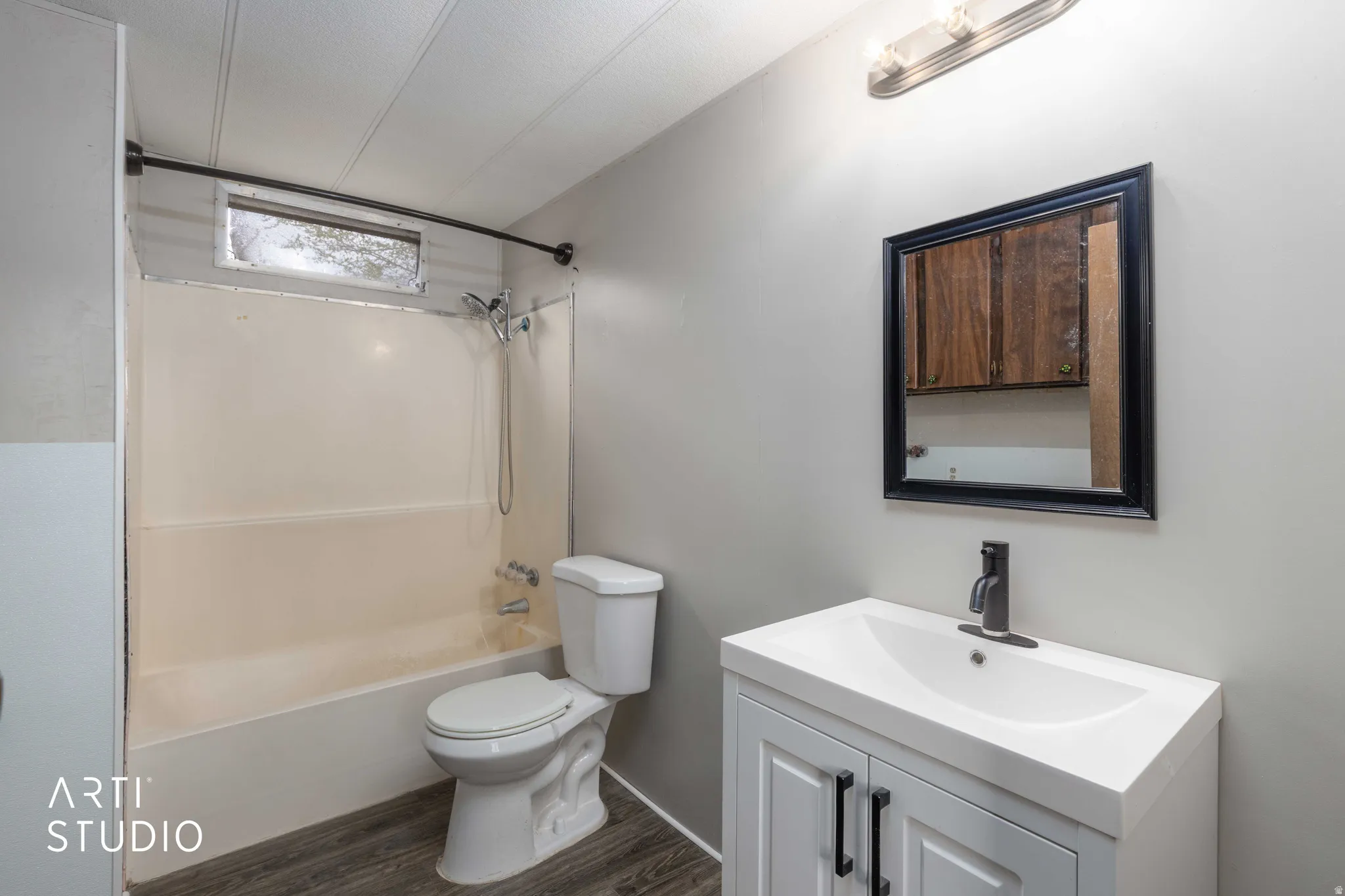 Full bathroom featuring vanity, washtub / shower combination, and dark wood finished floors