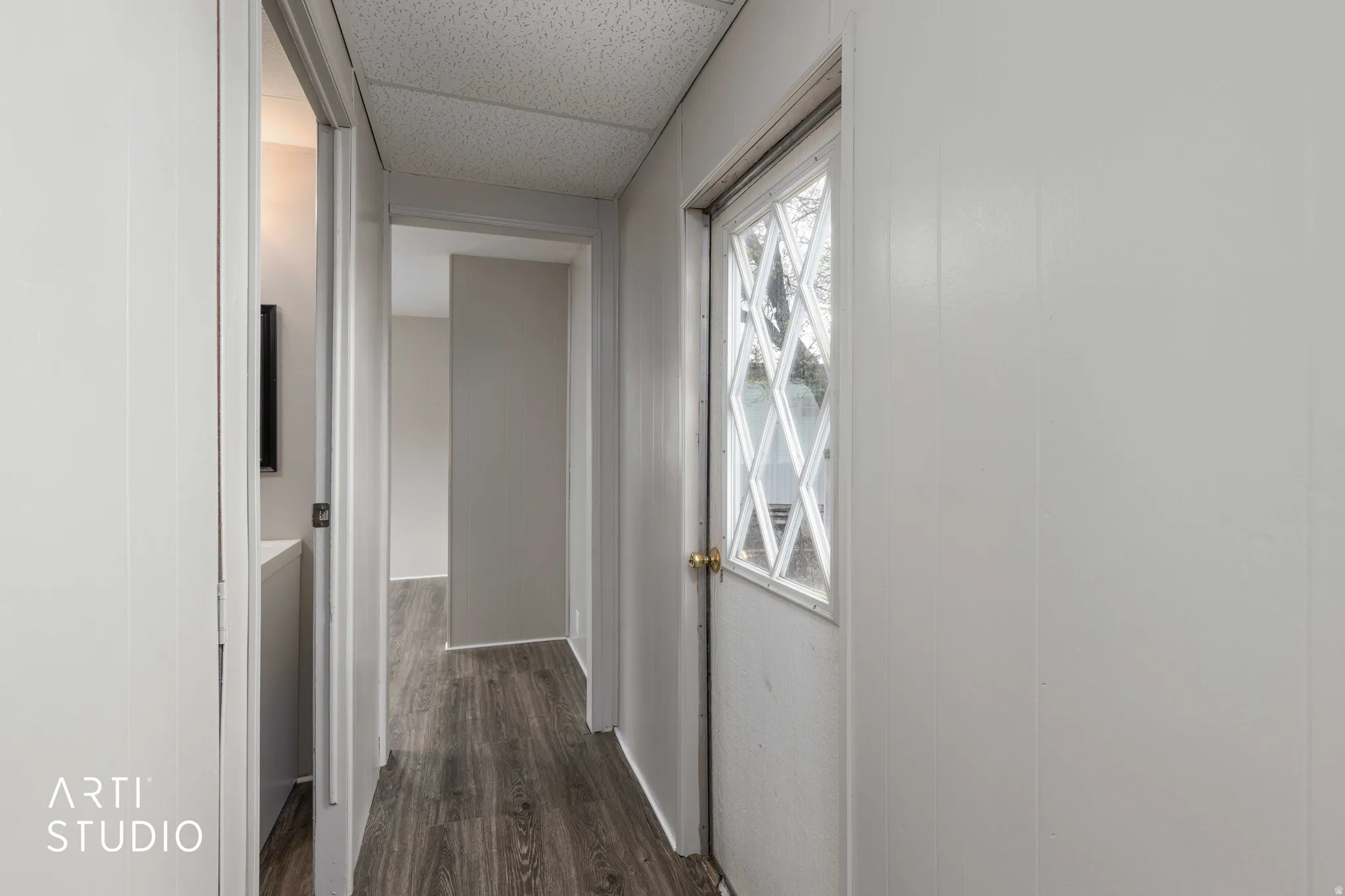 Corridor with dark wood-style flooring and a drop ceiling