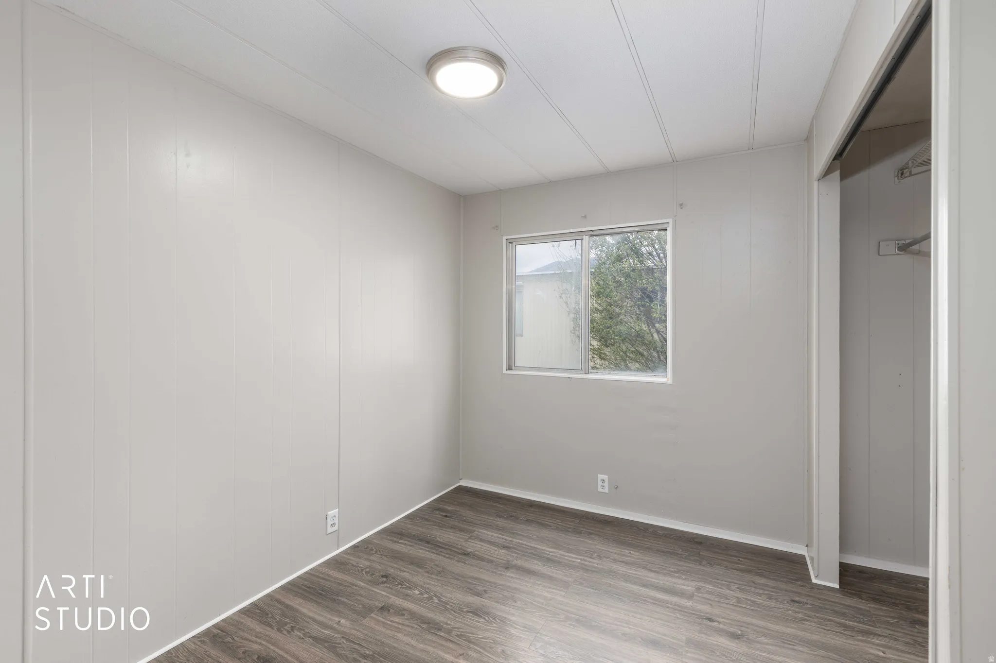 Unfurnished bedroom with dark wood-type flooring and a closet