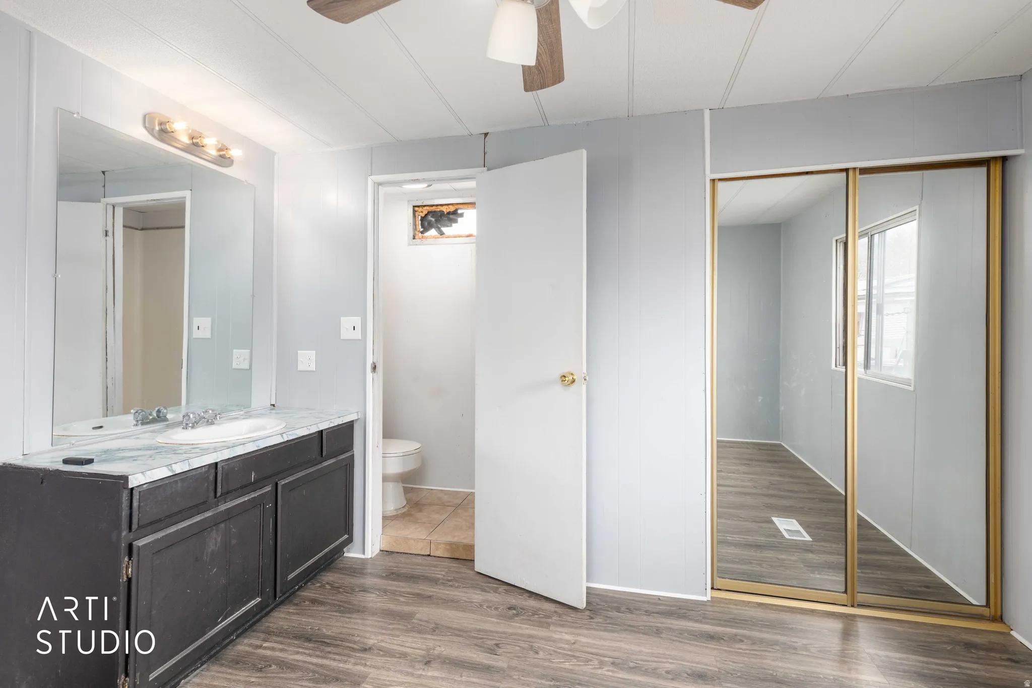 Bathroom with vanity, dark wood-style floors, and a ceiling fan