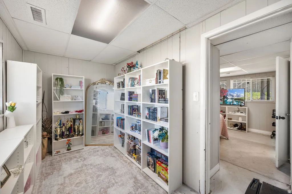 Miscellaneous room with a drop ceiling and wood walls