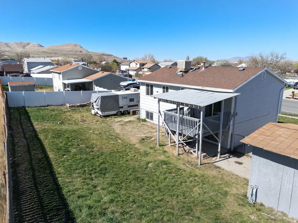 Back of house featuring a yard, a residential view, and a deck with mountain view