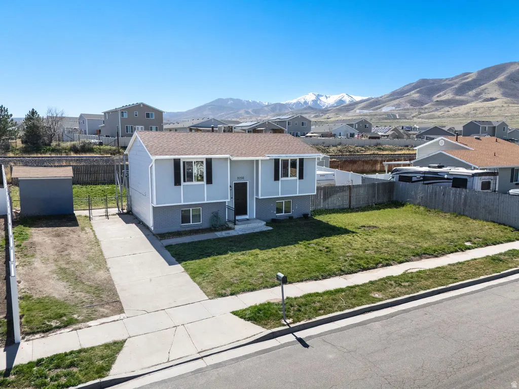 Raised ranch featuring a residential view, brick siding, and a mountain view