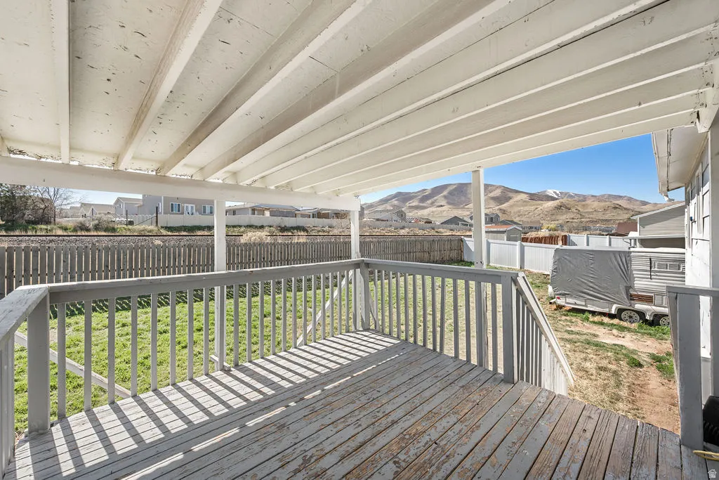 Wooden terrace with a mountain view and a fenced backyard