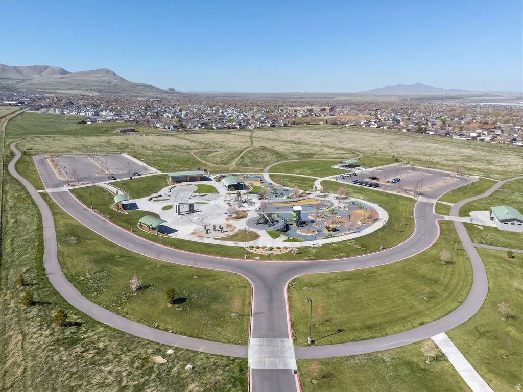 Aerial view of property and surrounding area featuring nearby suburban area and a mountain backdrop