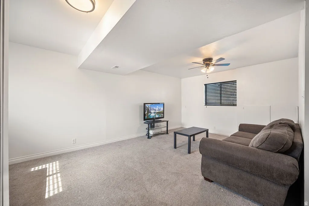 Living room with light carpet and a ceiling fan