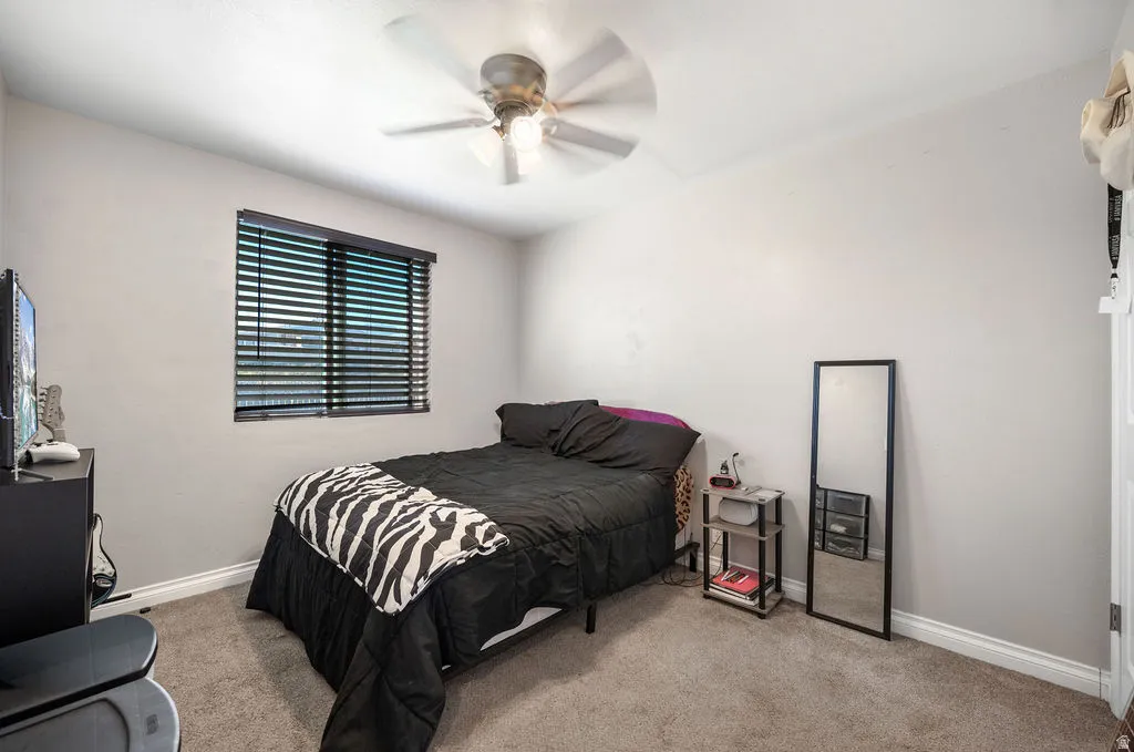 Bedroom with light colored carpet and ceiling fan