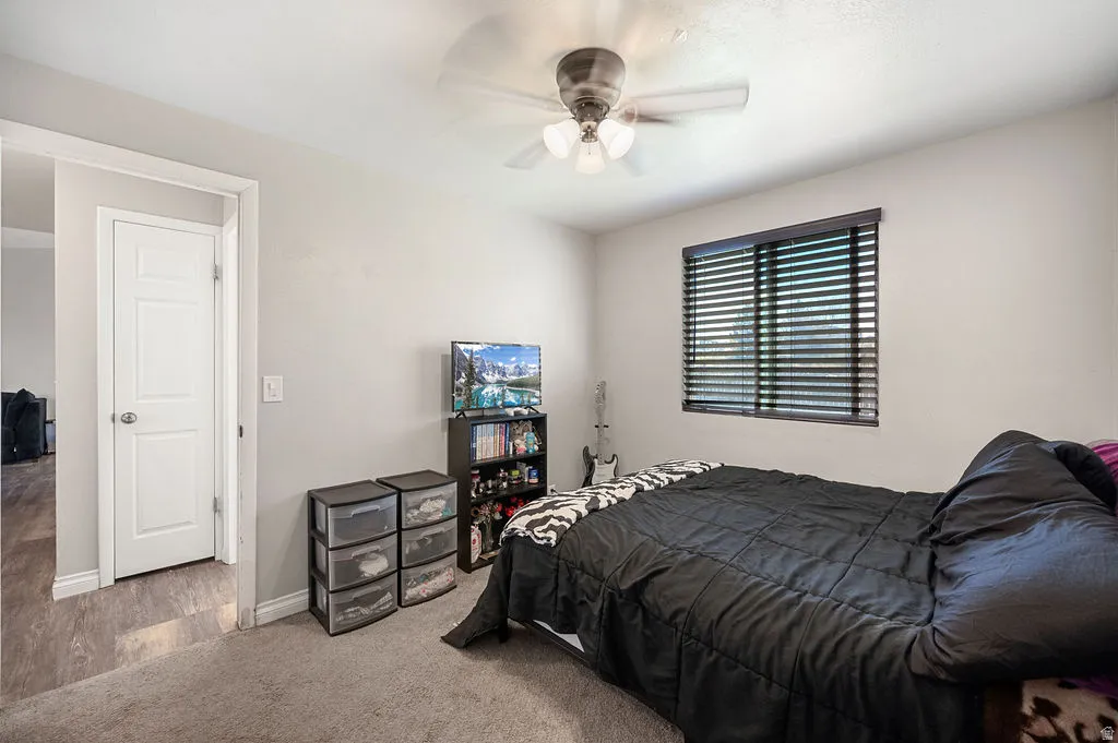 Carpeted bedroom with baseboards and a ceiling fan