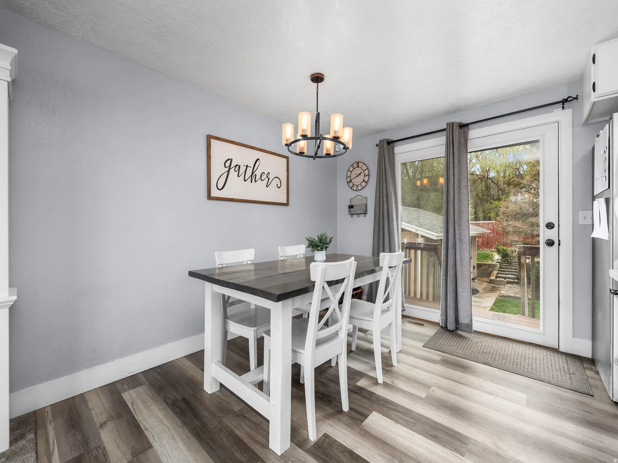 Dining space with light wood-style flooring, hanging lights, and a textured ceiling