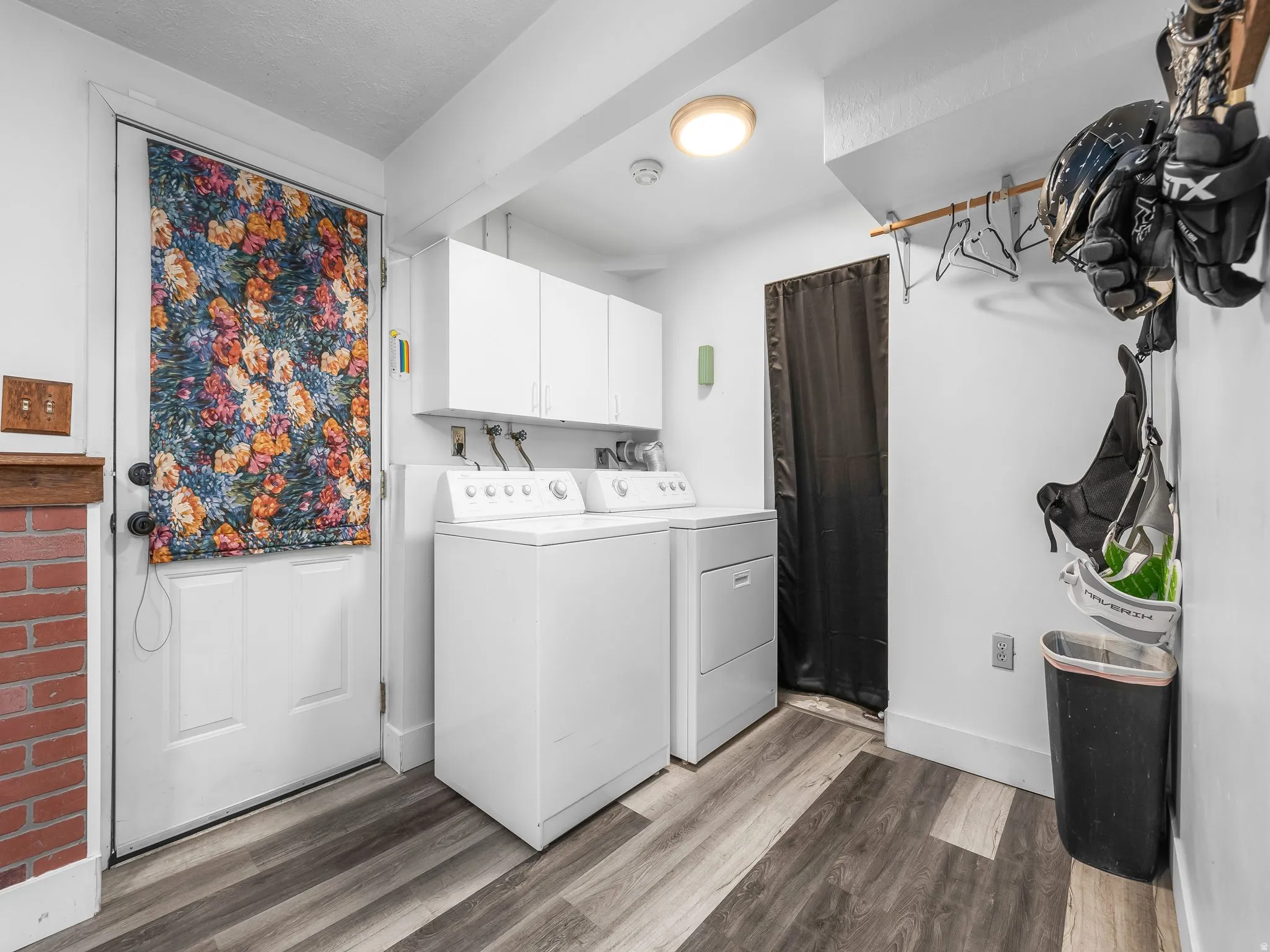 Laundry area with separate washer and dryer, dark wood finished floors, and cabinet space