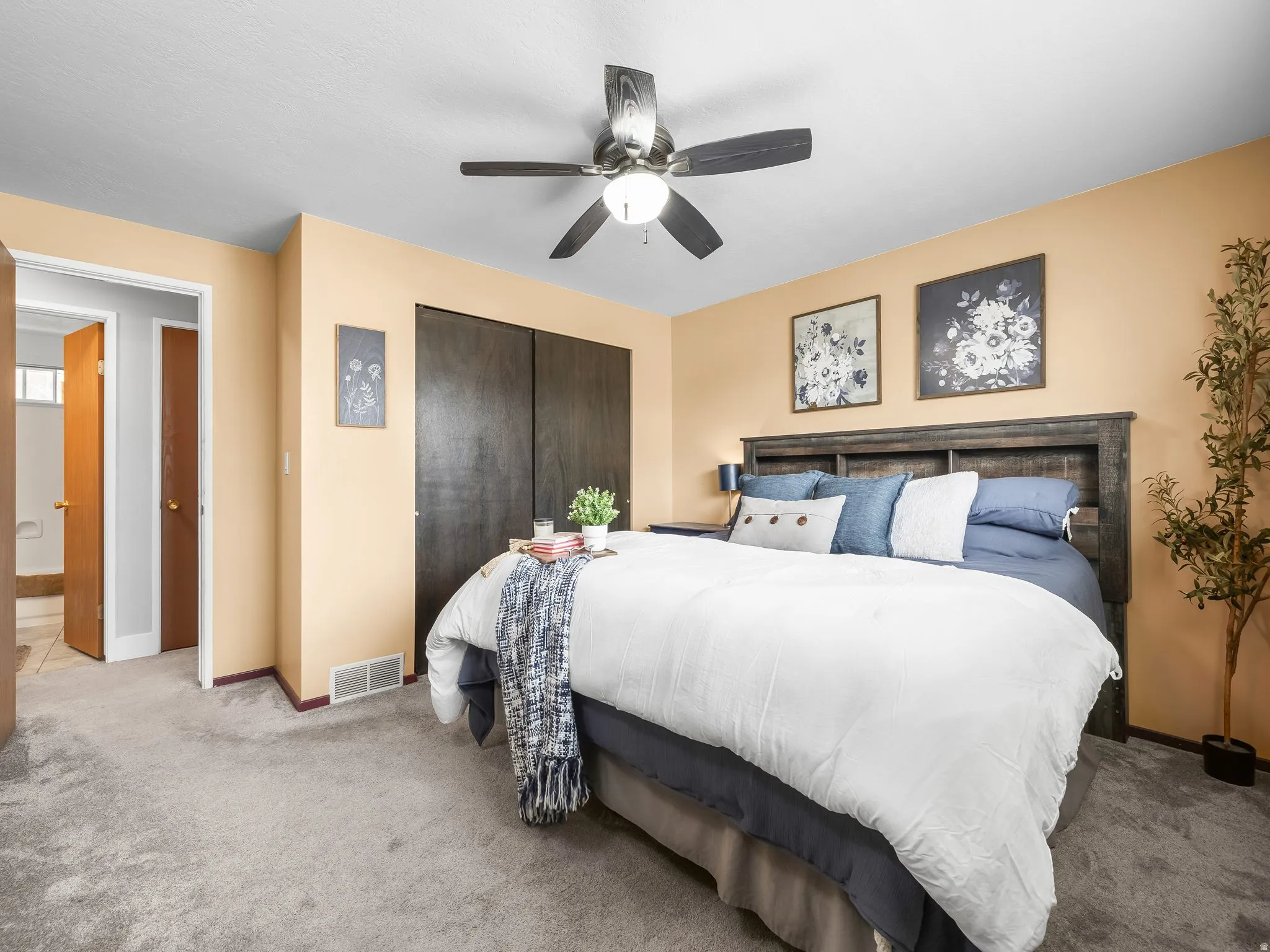 Carpeted bedroom featuring ceiling fan and a closet