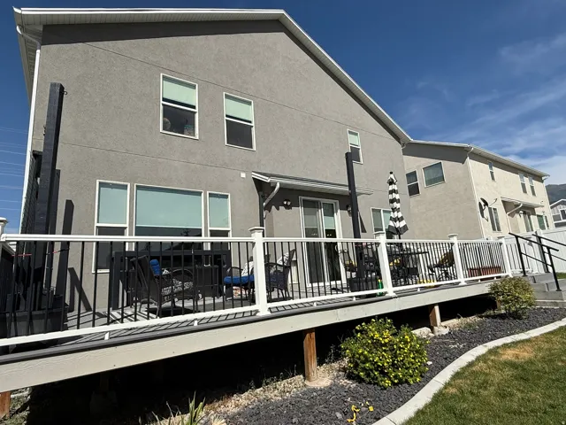 Back of house with a wooden deck and stucco siding
