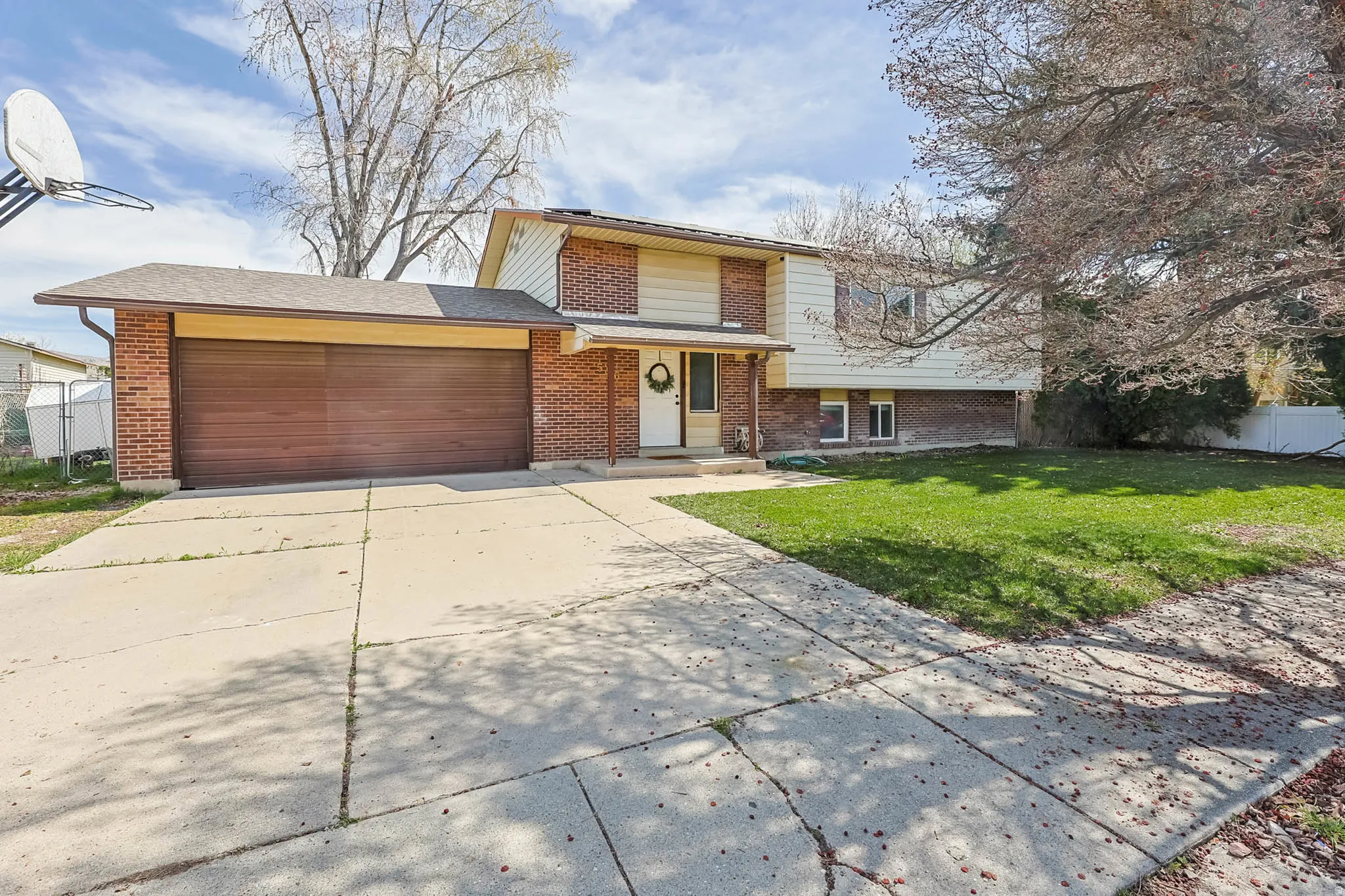 Tri-level home with brick siding, concrete driveway, and a garage
