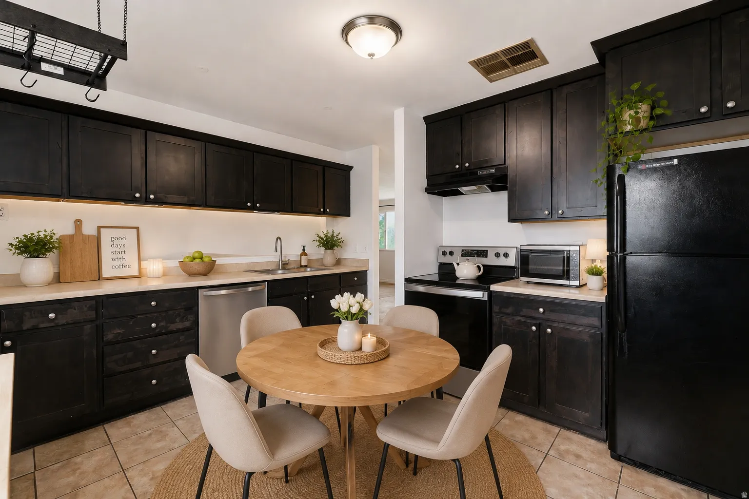 Kitchen featuring dark cabinetry, light countertops, stainless steel appliances, and tile flooring
