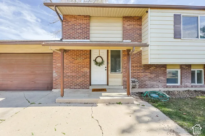 Front elevation showcasing a split-level design with brick and siding facade