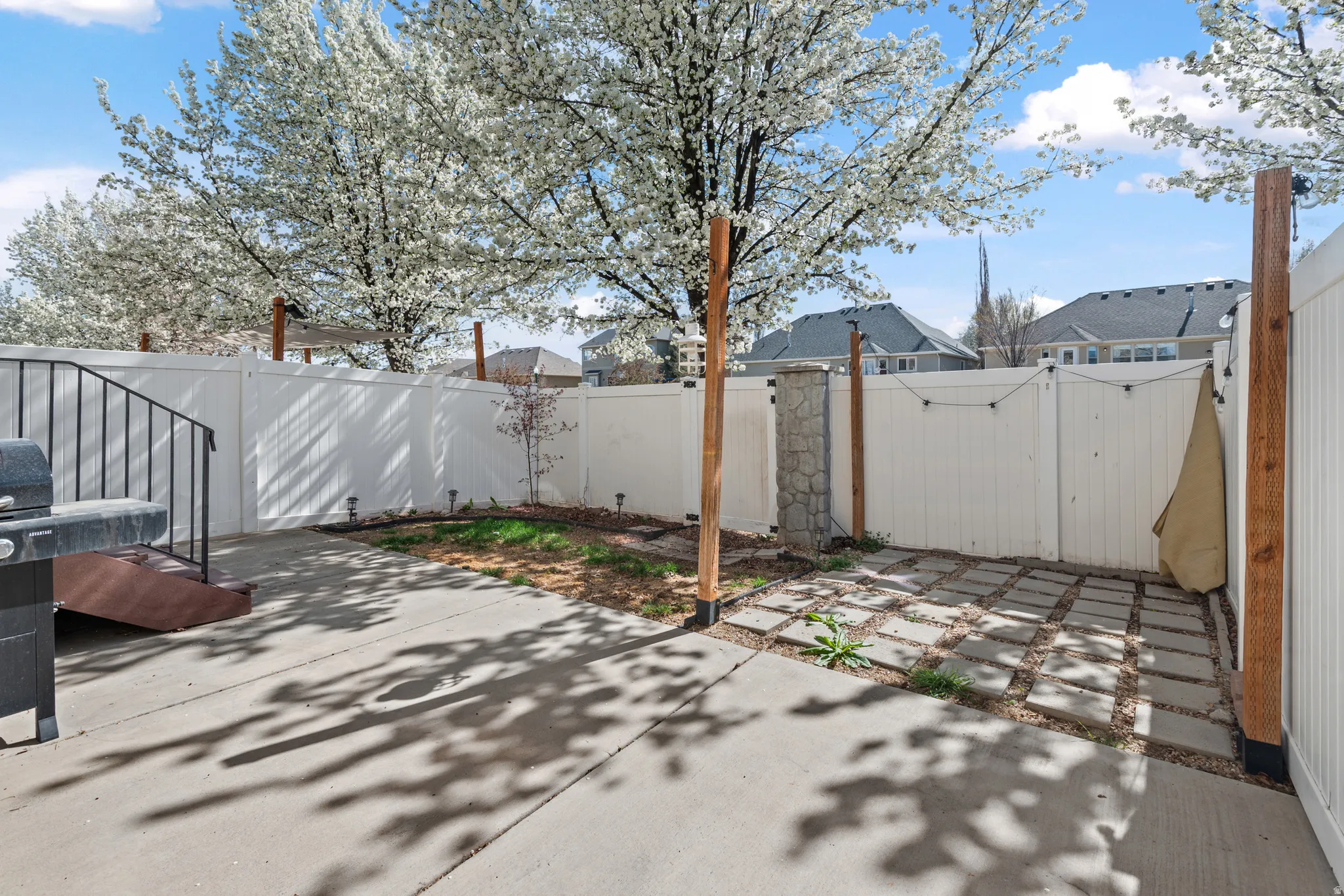 Fenced backyard featuring a gate, area for grilling, a patio area, and a residential view