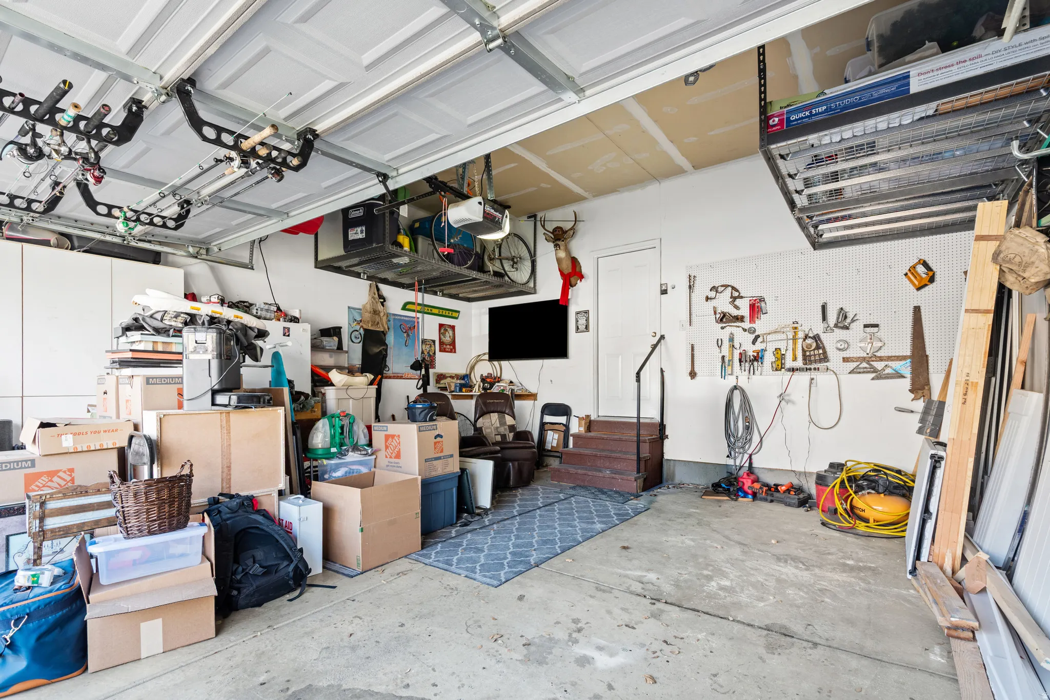 Garage- Ample storage with overhead racks. Additional racks above the garage door that aren't visible in this photo!