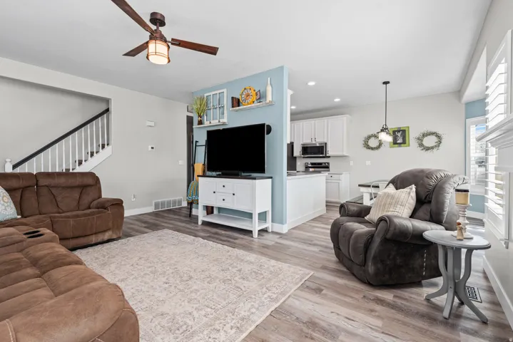 Living area with light wood-style floors, recessed lighting, and a ceiling fan
