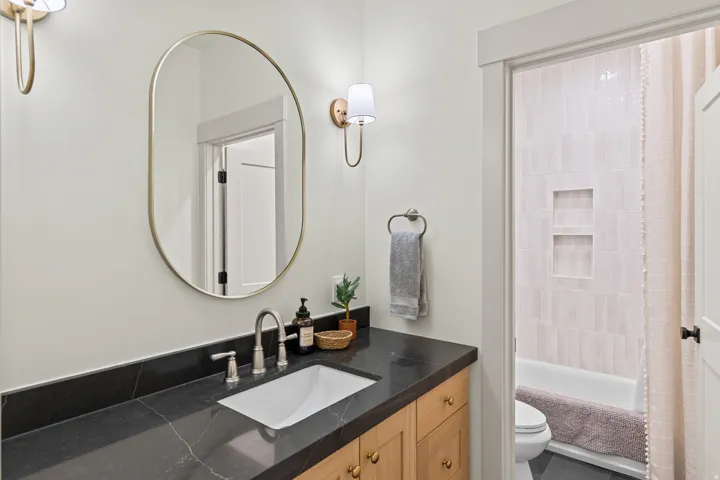 Full bathroom off Kitchen. White Oak Cabinetry with Quartz counter tops.