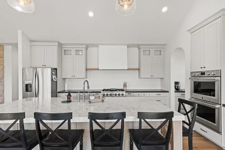 White oak Island with "Accessible Beige" by SW surrounding cabinetry with ceiling height doors. Most lower cabinetry are drawer with so much storage.
