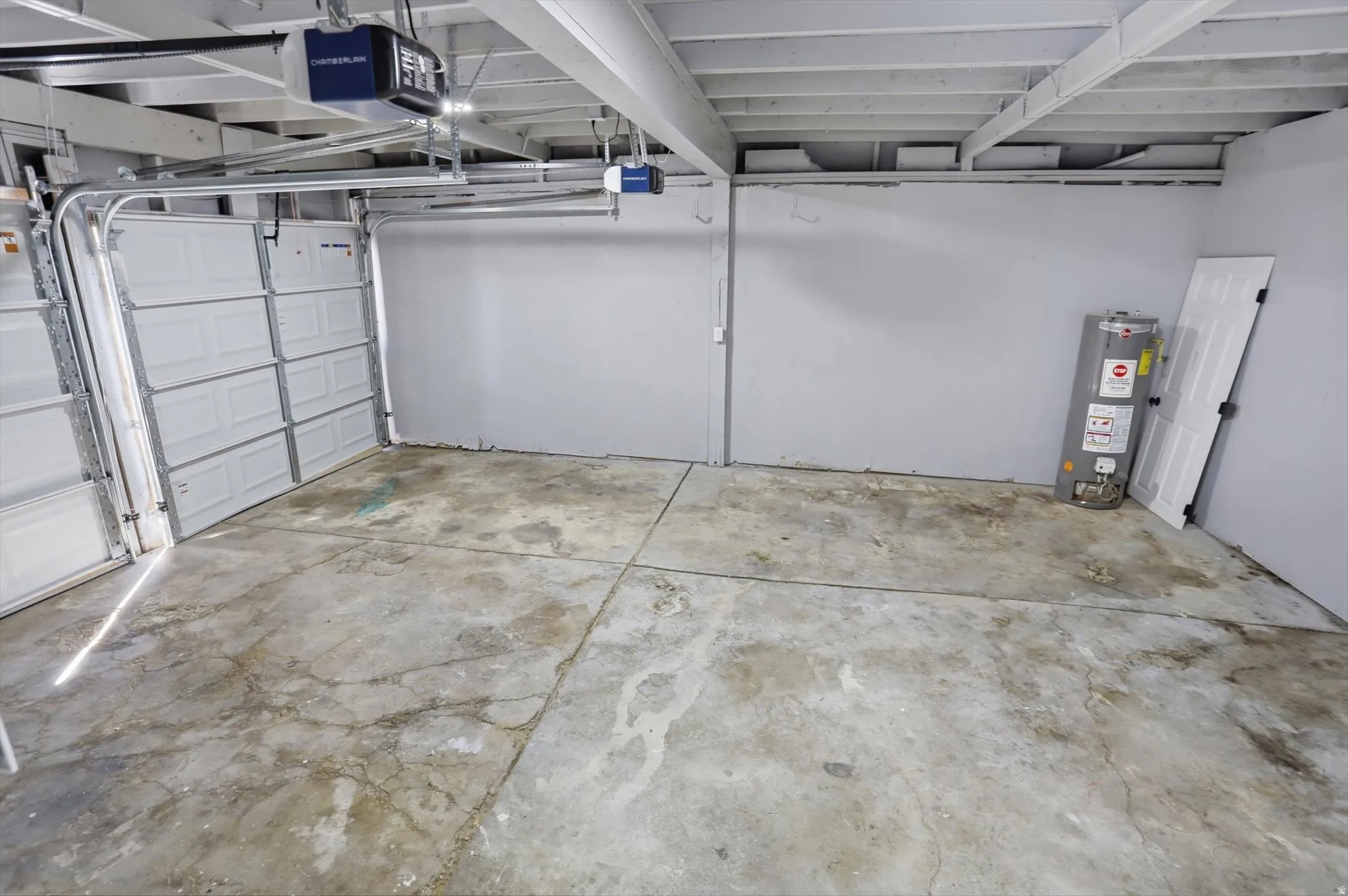 Garage with gas water heater and a garage door opener