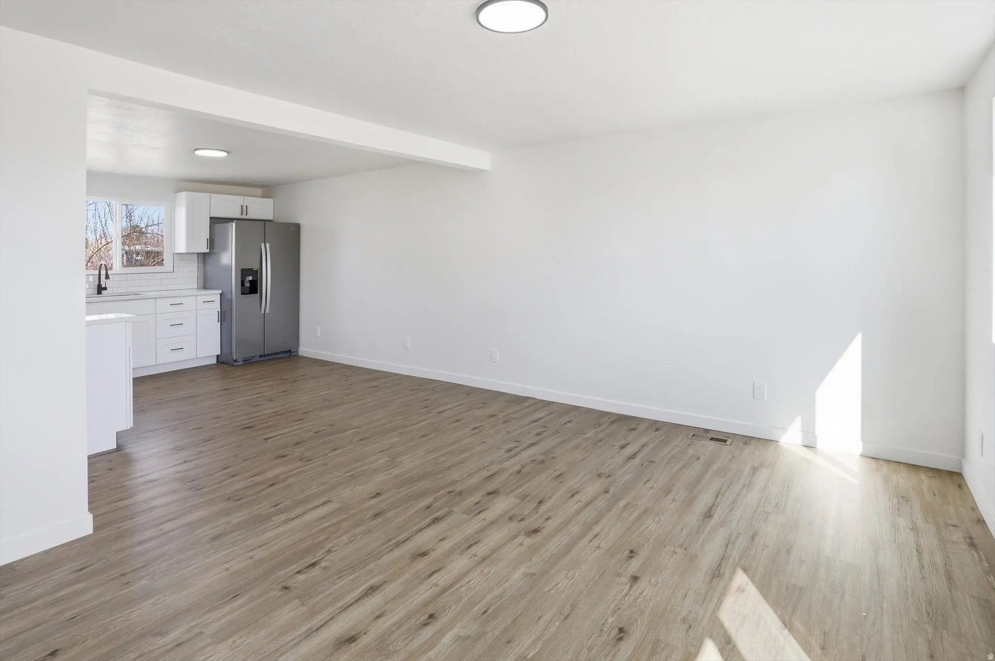 Unfurnished living room featuring light wood-style flooring