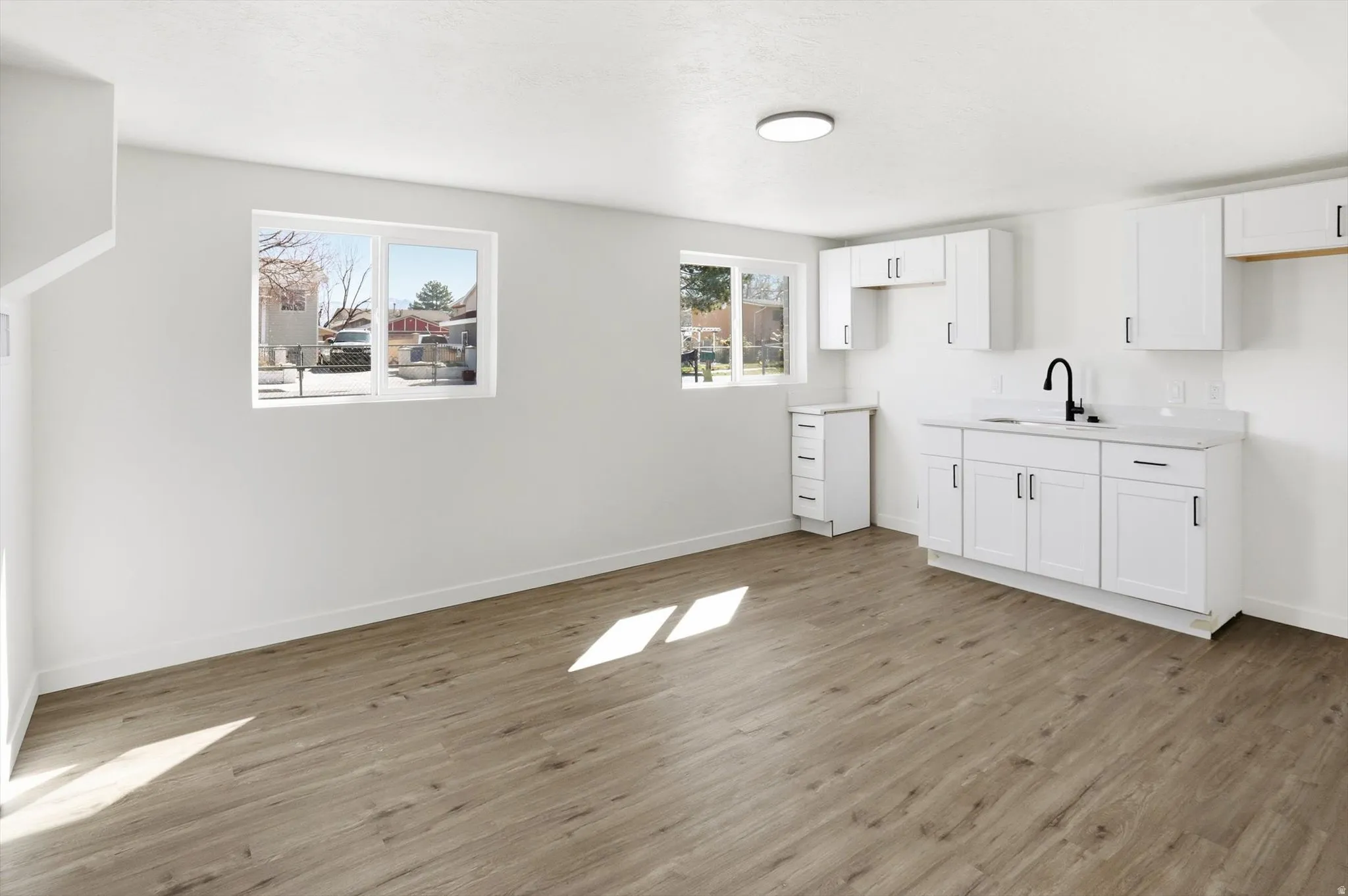 Kitchen featuring white cabinetry, light countertops, and light wood finished floors