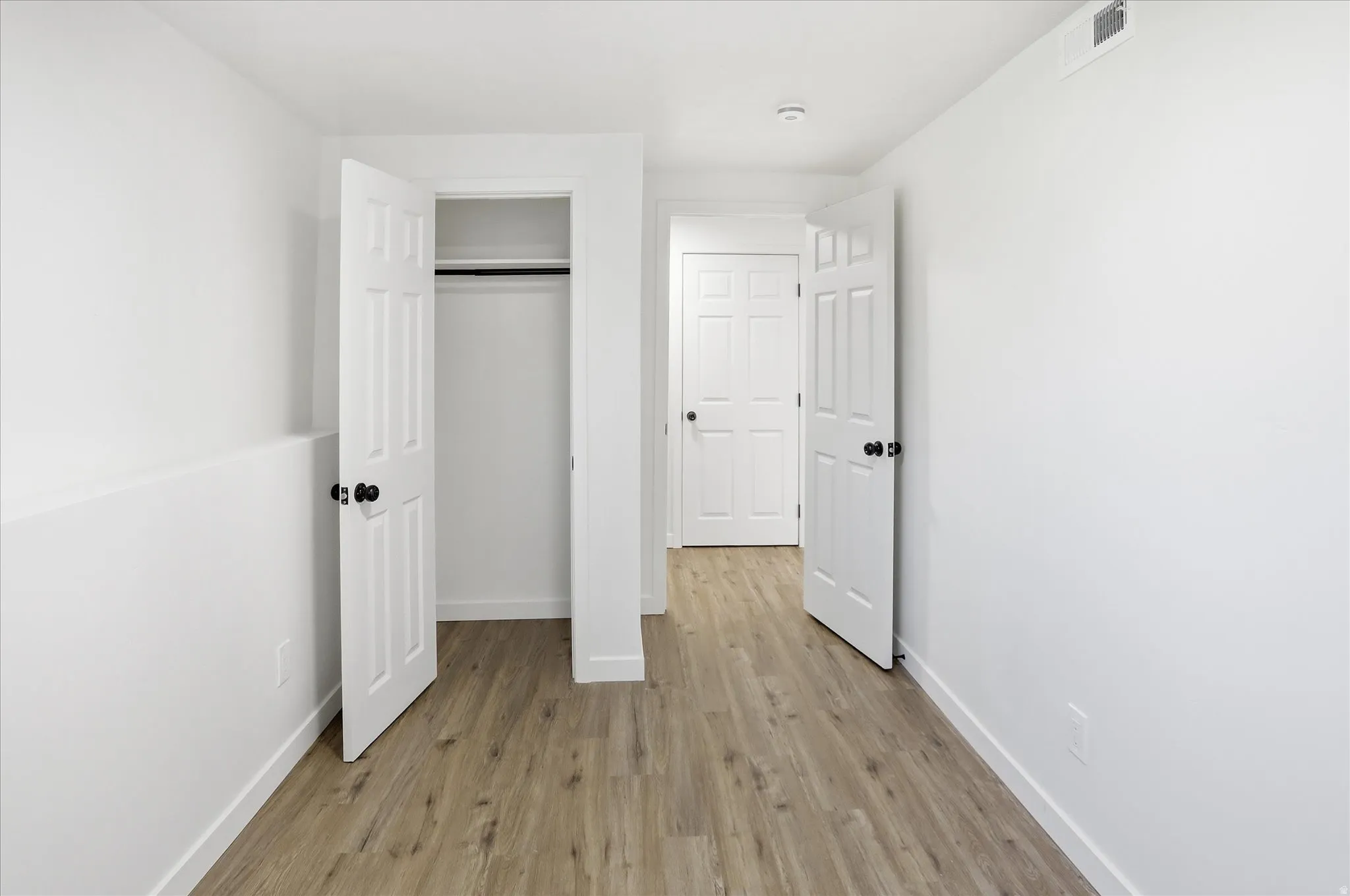 Unfurnished bedroom featuring light wood-style floors and a closet