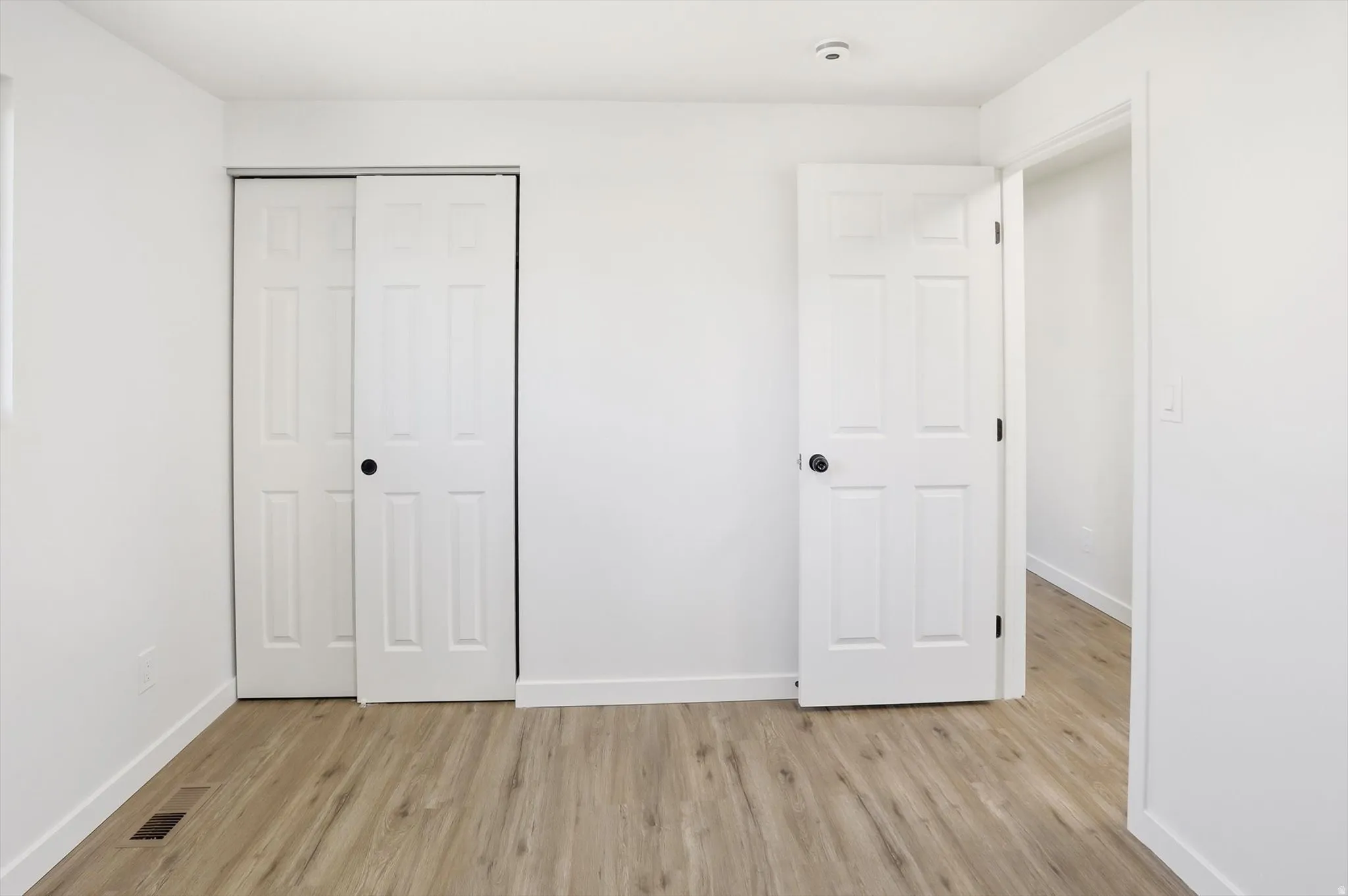 Unfurnished bedroom with a closet and light wood-type flooring