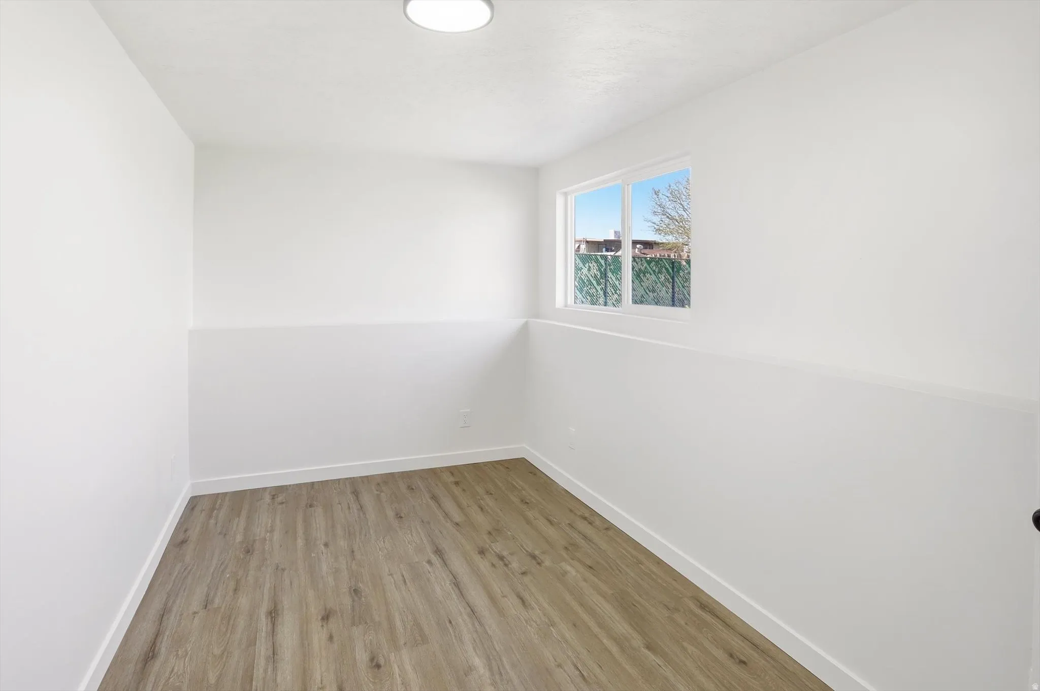 Spare room featuring light wood-style floors and baseboards