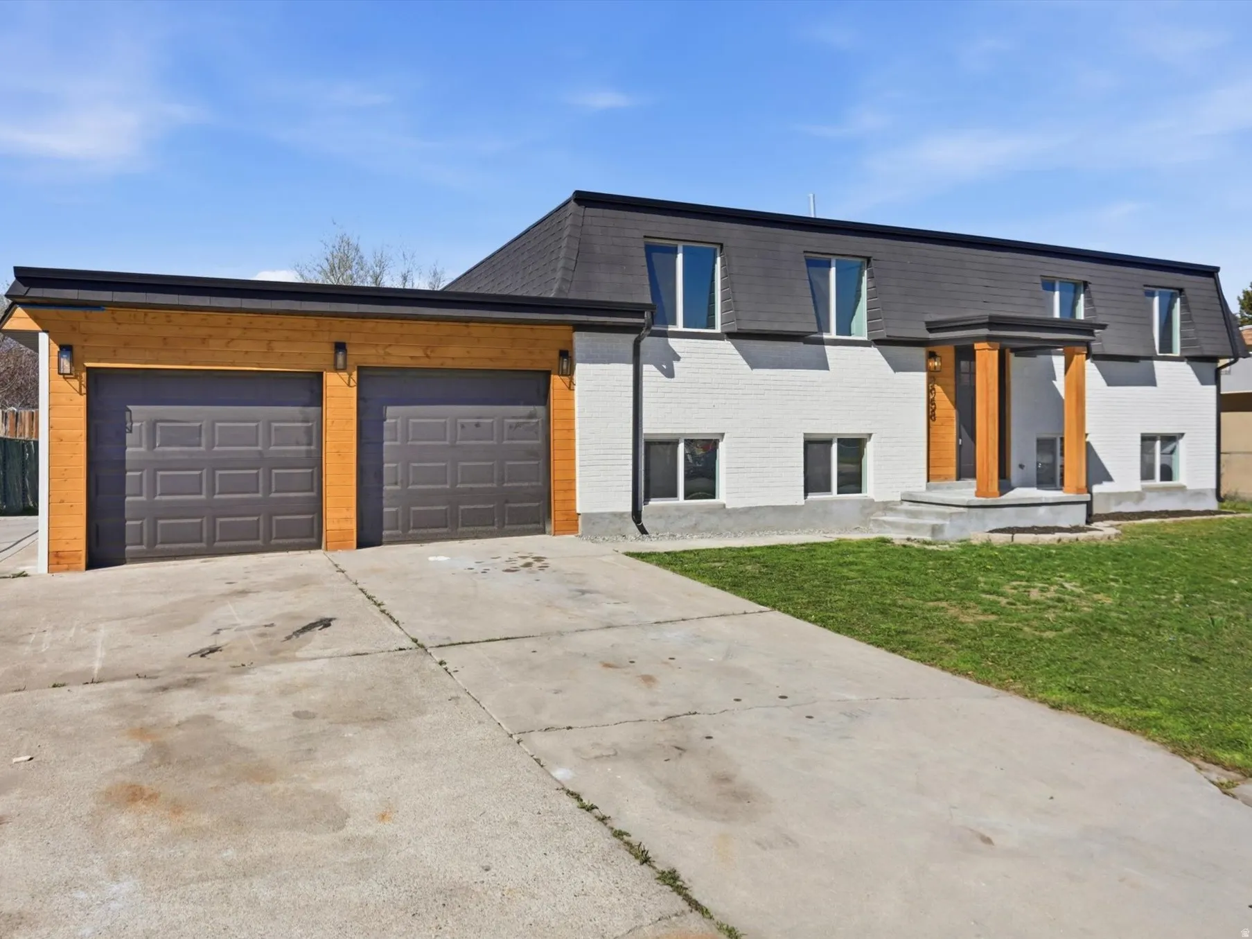 View of front of property with brick siding, concrete driveway, and a garage