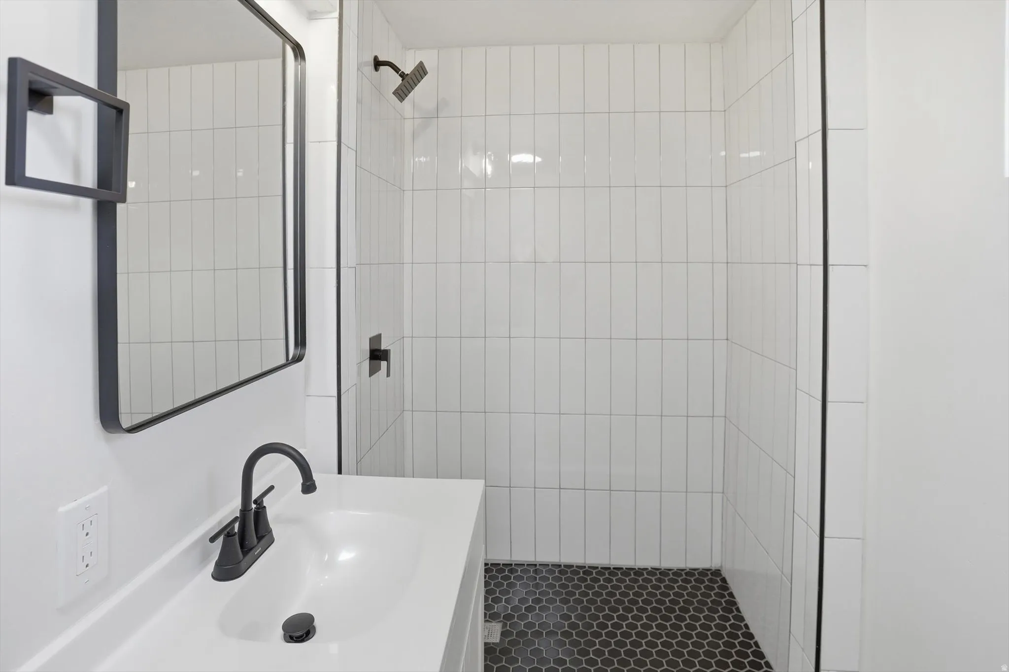 Full bath with vanity and a tile shower