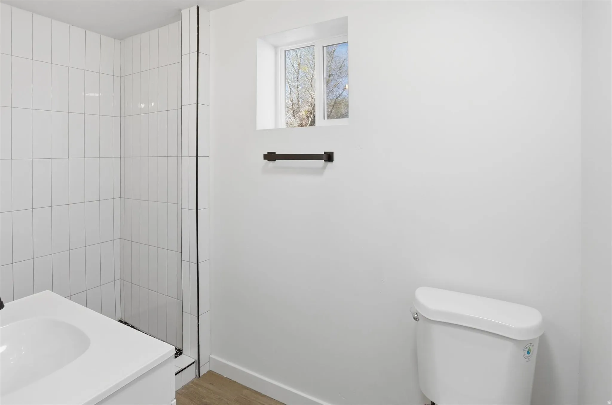 Full bathroom with vanity, a stall shower, and light wood-style flooring
