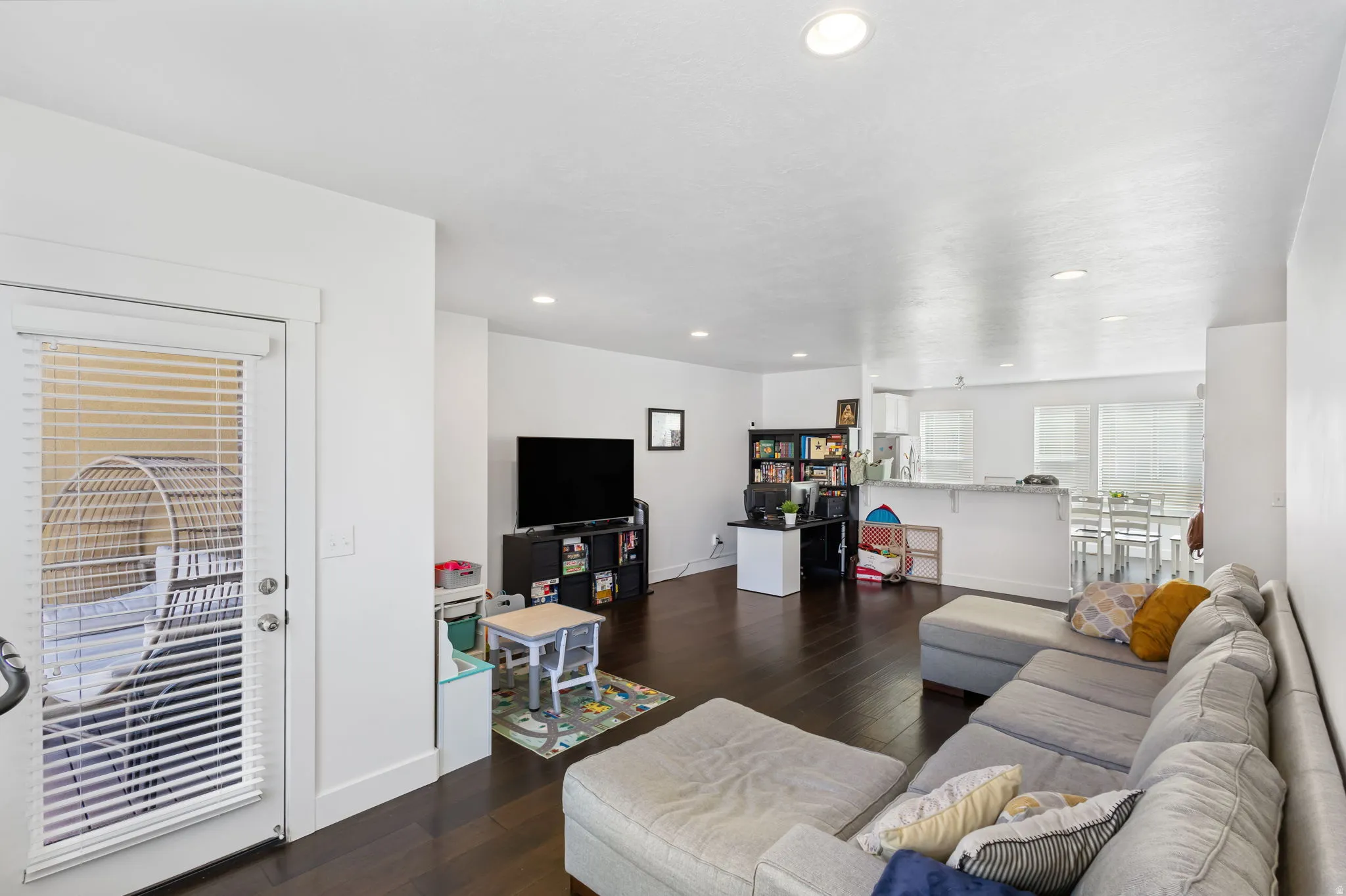 Living room with dark wood-style flooring and recessed lighting