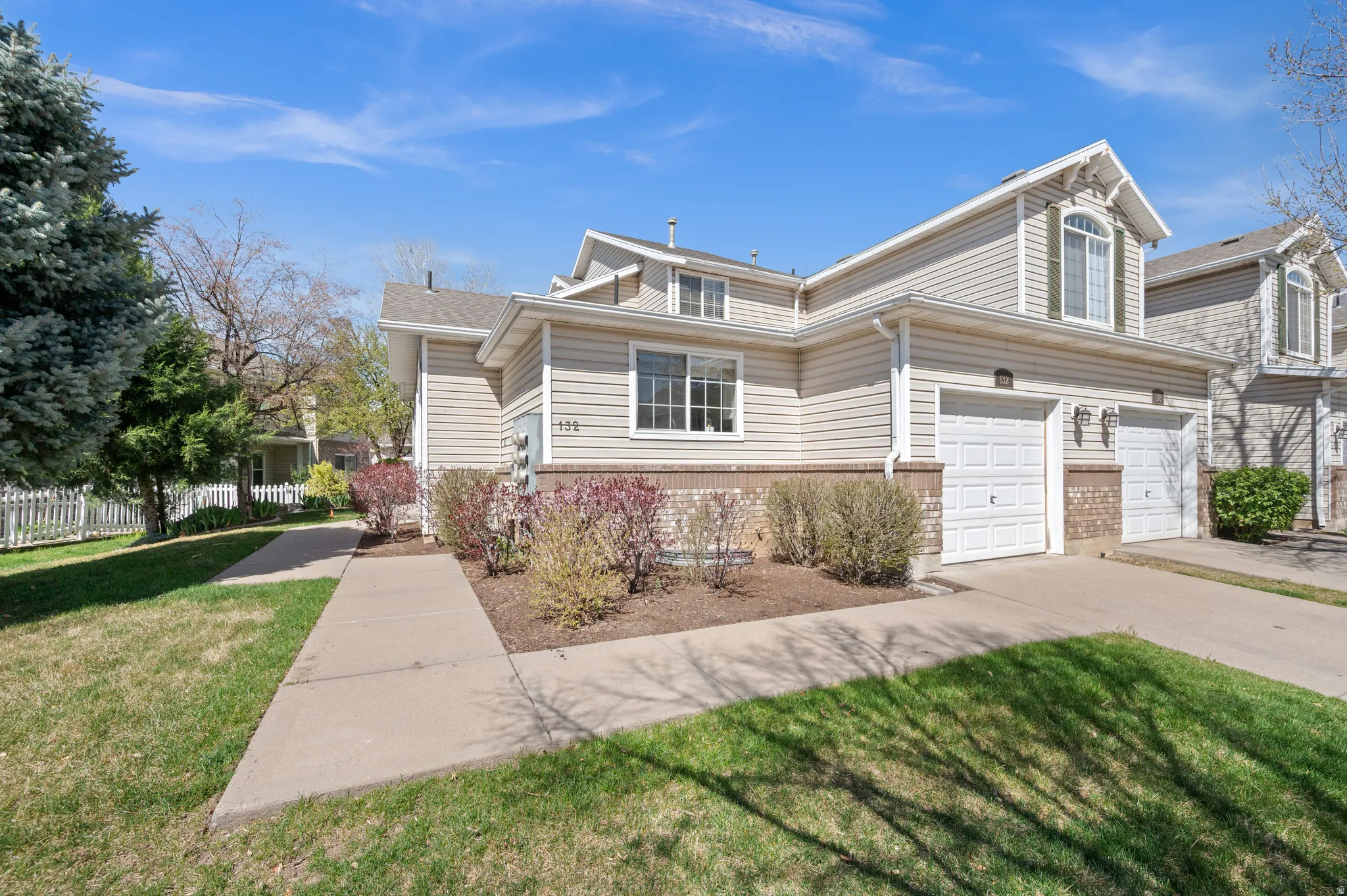 View of front facade featuring driveway and brick siding