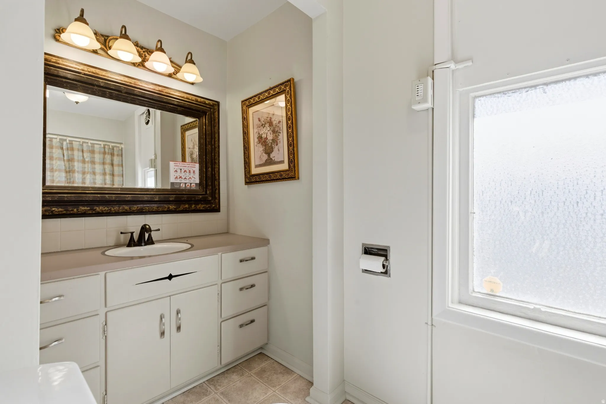 Full bathroom featuring vanity, curtained shower, decorative backsplash, and plenty of natural light