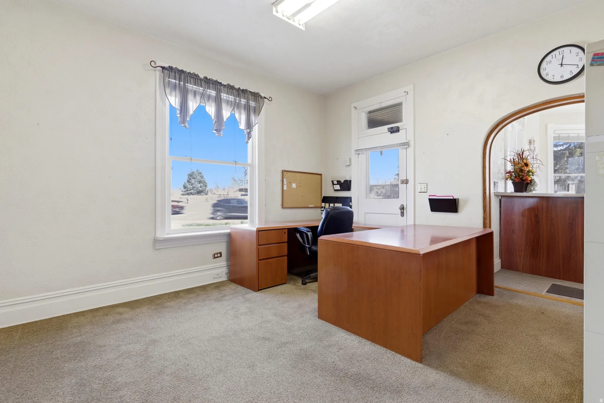 Home office featuring light colored carpet and baseboards