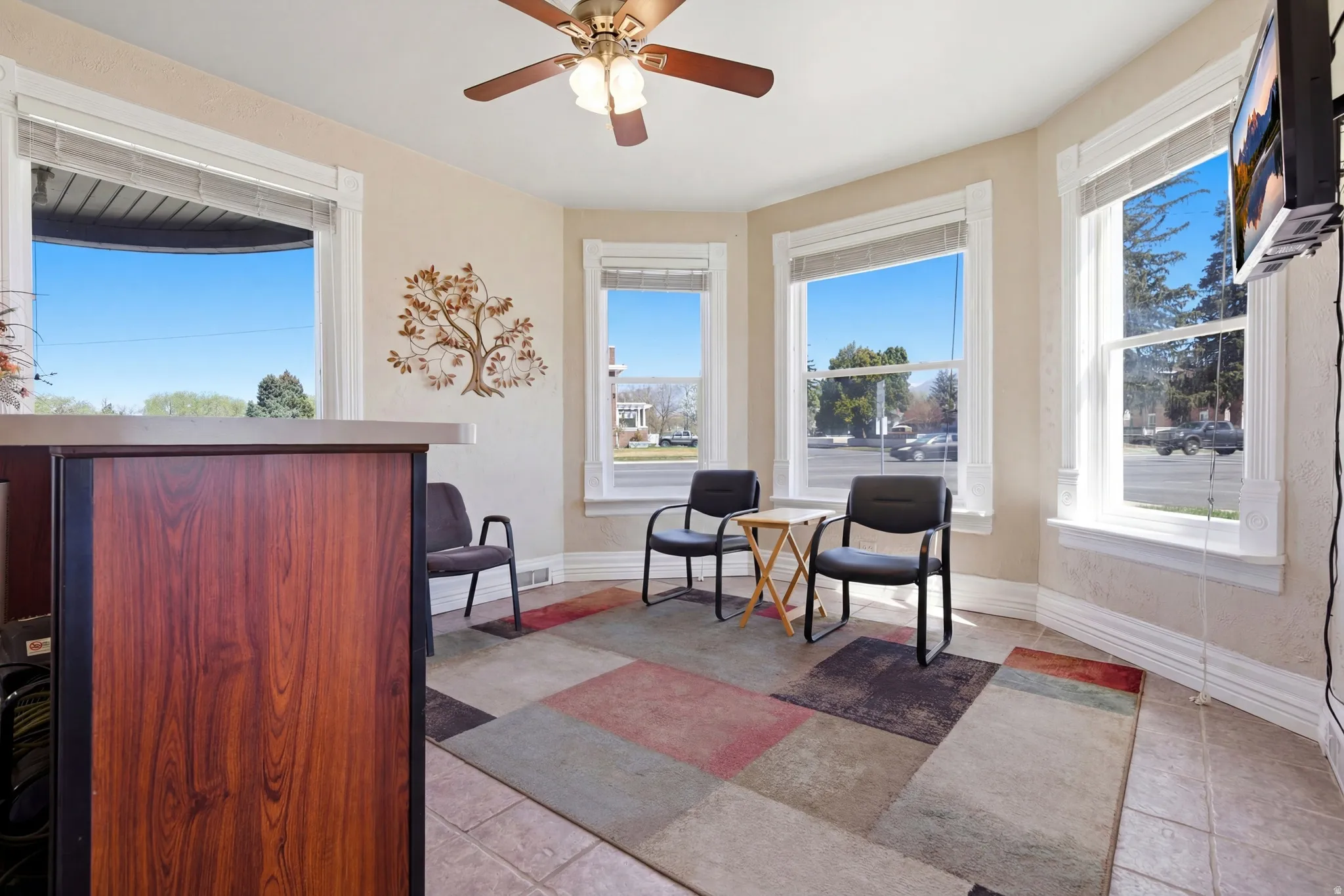 Living area featuring plenty of natural light, a ceiling fan, and light tile patterned floors