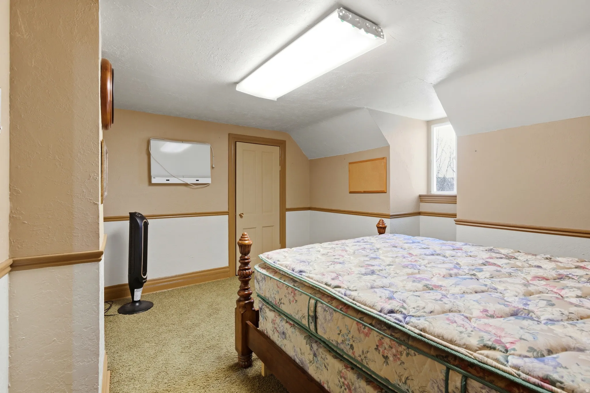 Bedroom featuring light carpet and vaulted ceiling